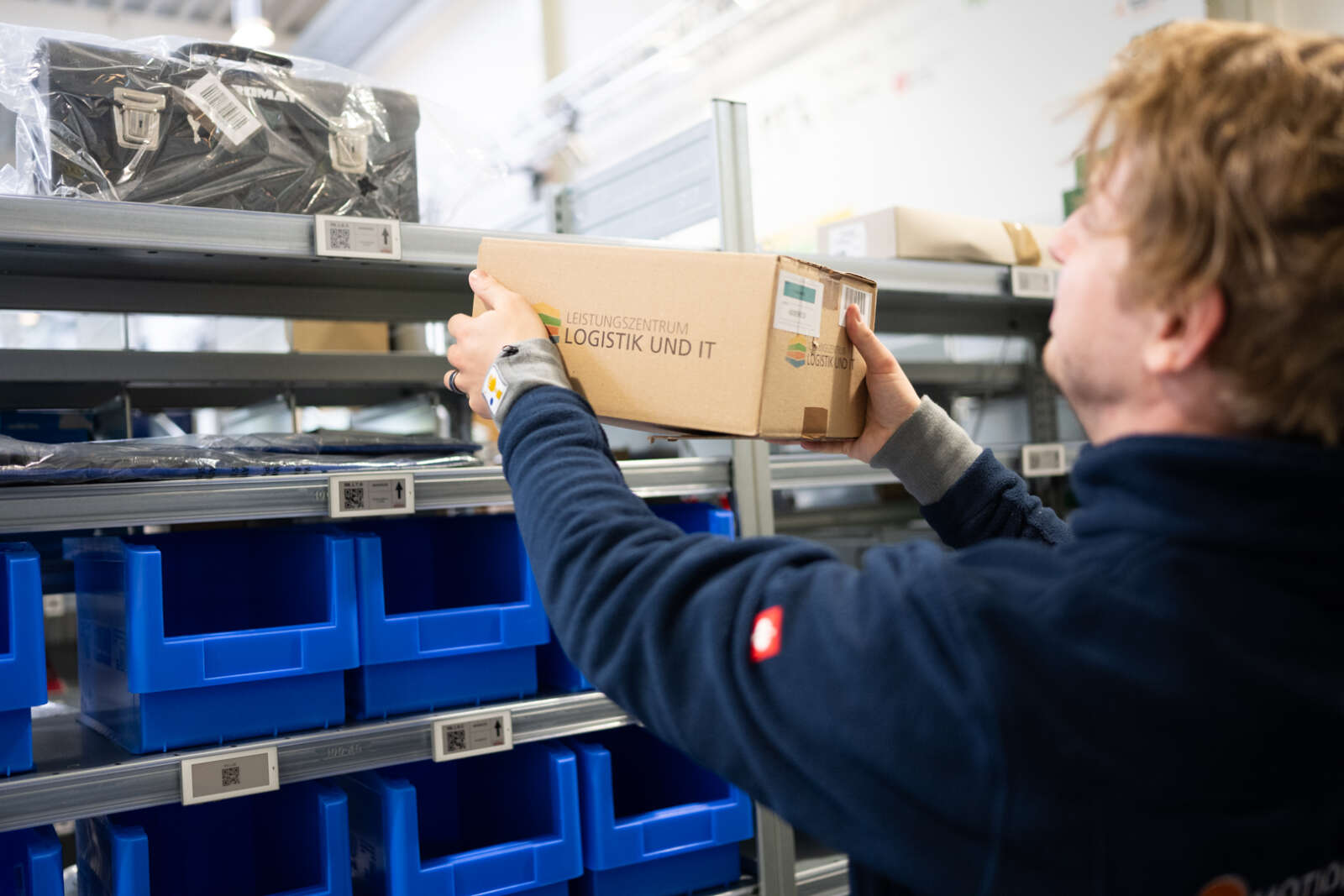Frau stellt Karton im Picking Lab ins Regal